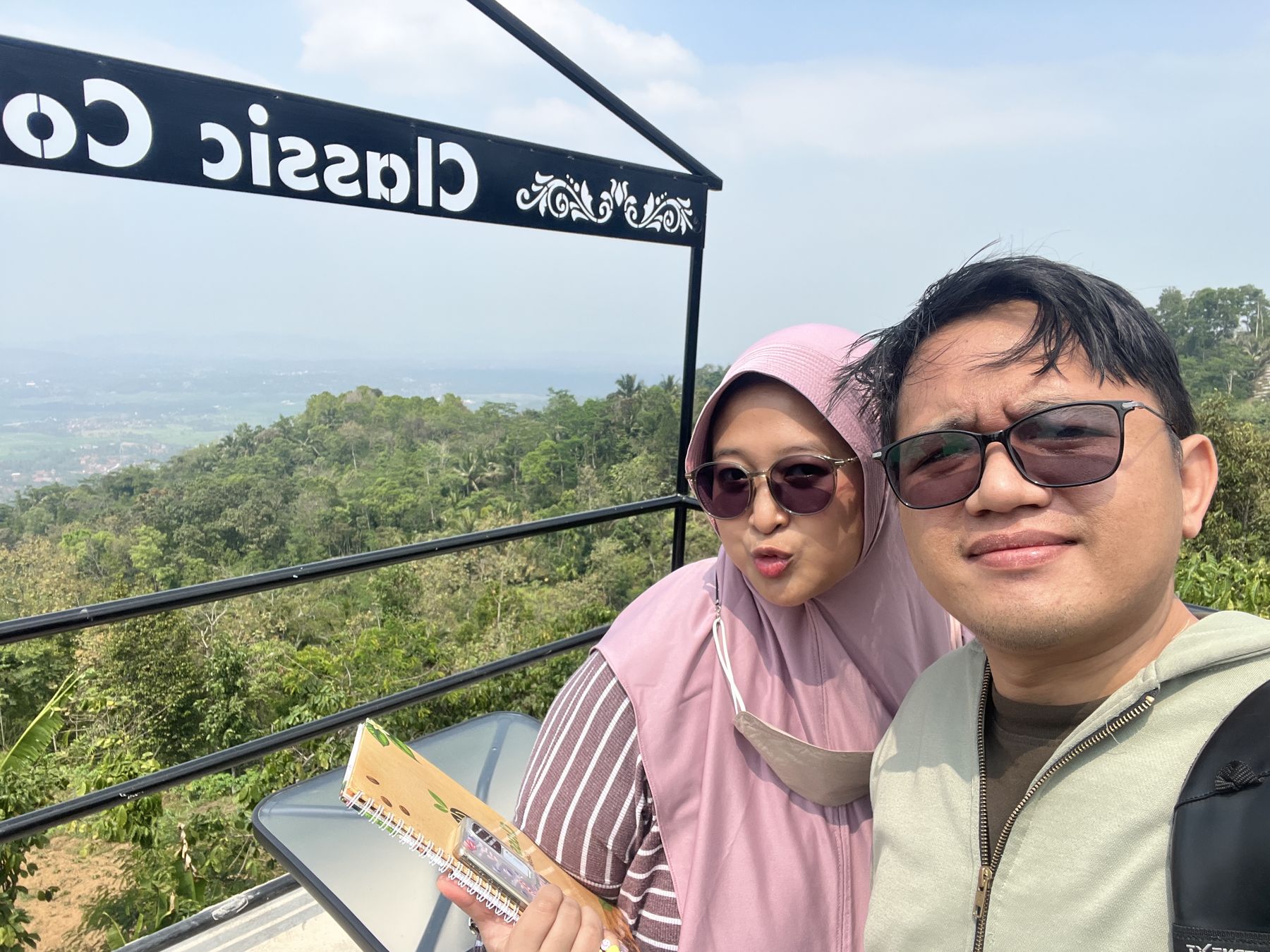 Bonggo dan Mutiara berfoto bersama dengan pemandangan perbukitan